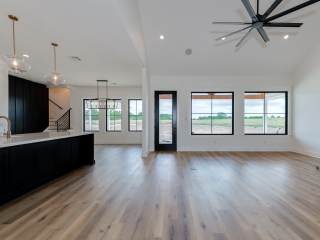Unfurnished living room of the Homestead Project with food flooring and black details.