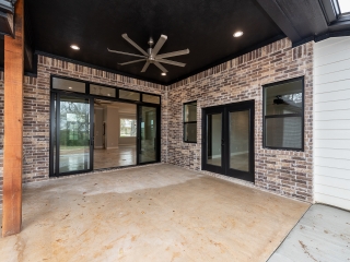 The Rovnovsky custom home patio with industrial fan and brick detail.