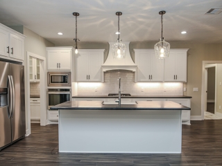 Farmhouse Project by LaFollette Custom Homes featuring large island and white cabinets.