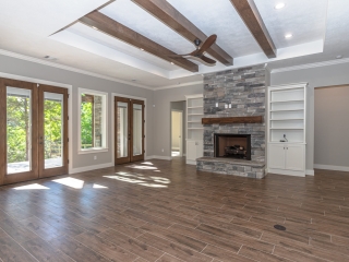 Living room of the Cedar Project by LaFollette Custom Homes with grey stone fireplace.