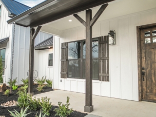 Dark weathered wooden front door on a custom home of The Farmhouse Project Custom Home with neutral wood details