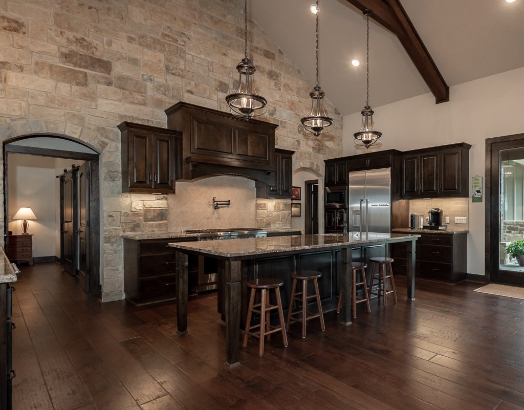 Custom home kitchen with dark wood cabinets and flooring.