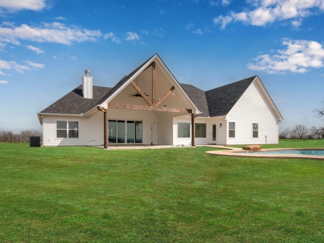 Axis Project by LaFollette Custom Homes: with white exterior and wood detailing on a green lawn.
