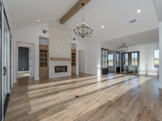 Unfurnished living room of the Hollow Project by LaFollette Custom Homes featuring stunning wood flooring.