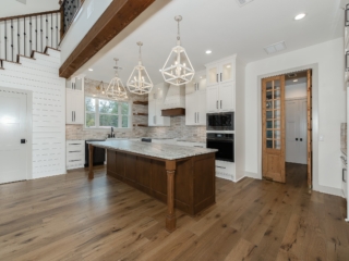 Kitchen of the Oak House Project by LaFollette Custom Homes with wood and marble island.