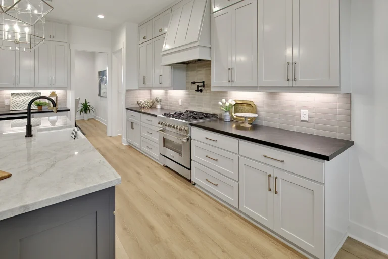Kitchen storage ideas in a custom home kitchen with deep drawers, tall cabinets, under-cabinet lighting, and a large island.