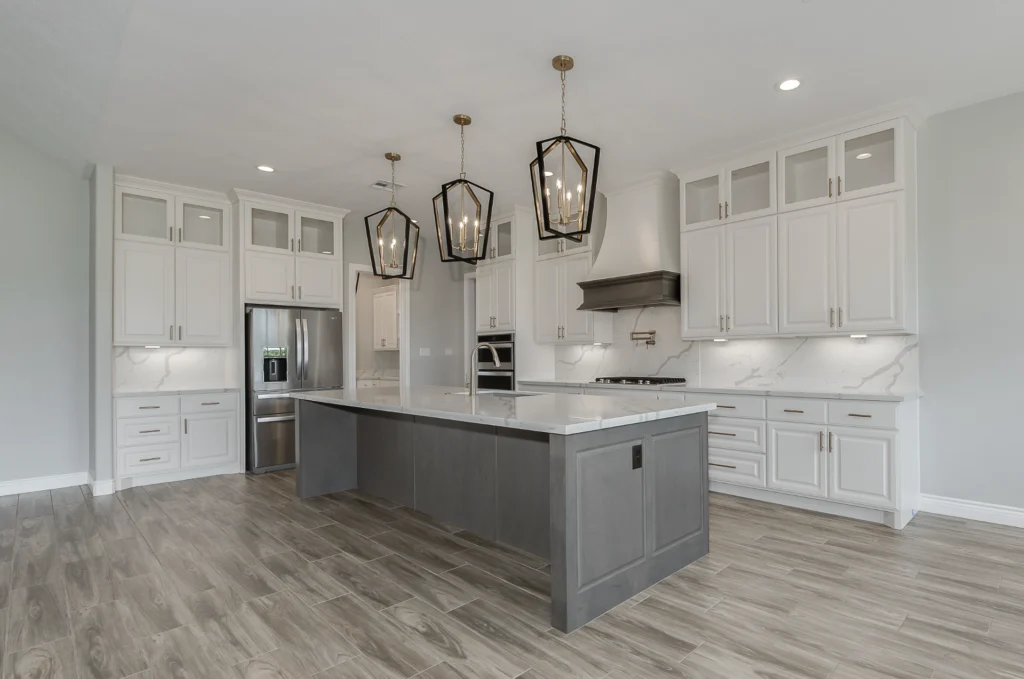 Custom home design details in a bright kitchen with large island and pendant lighting