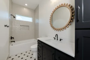 Custom bathroom by a custom home builder featuring black cabinetry and modern finishes