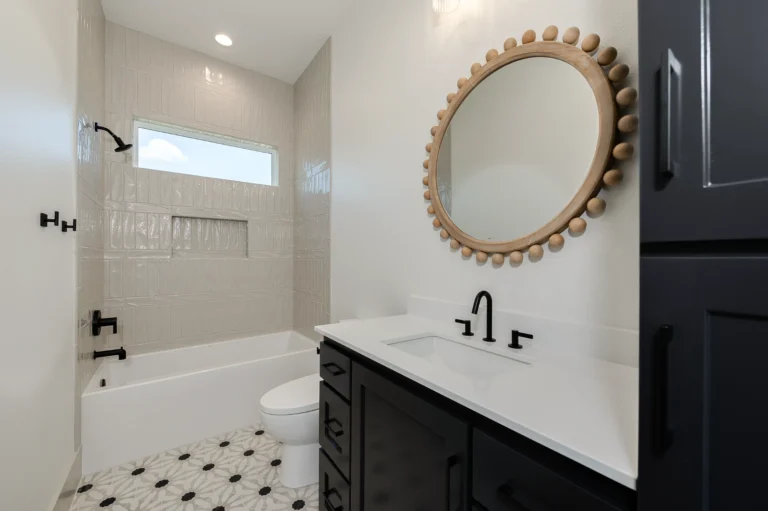 Custom bathroom by a custom home builder featuring black cabinetry and modern finishes