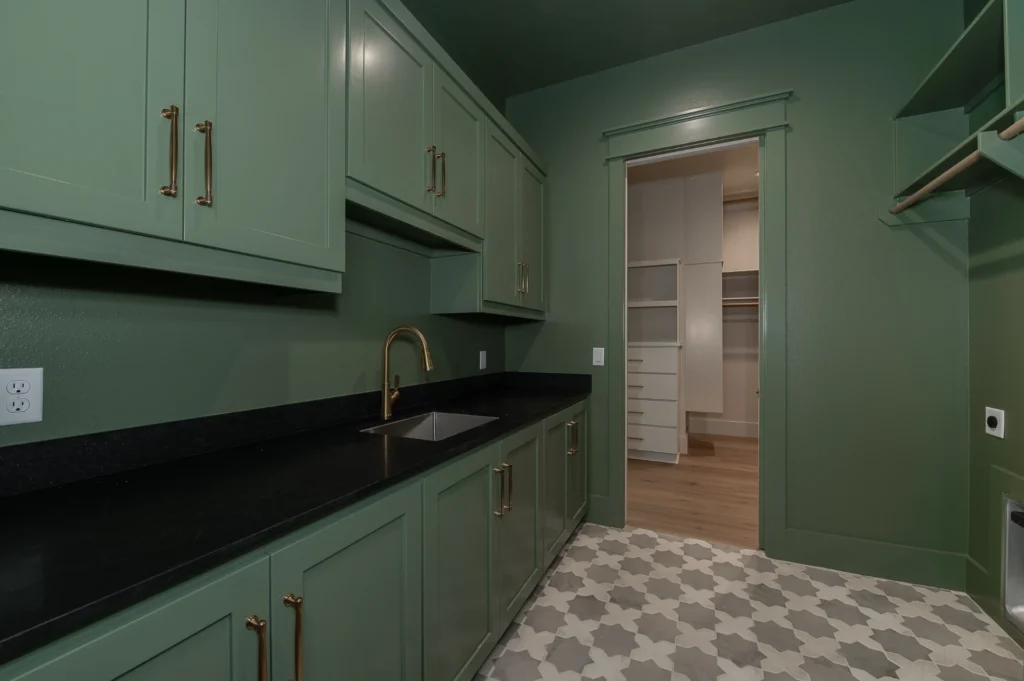 Stress-free custom home design featuring a green laundry room with custom cabinetry