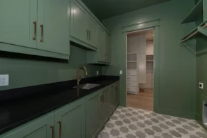 Stress-free custom home design featuring a green laundry room with custom cabinetry
